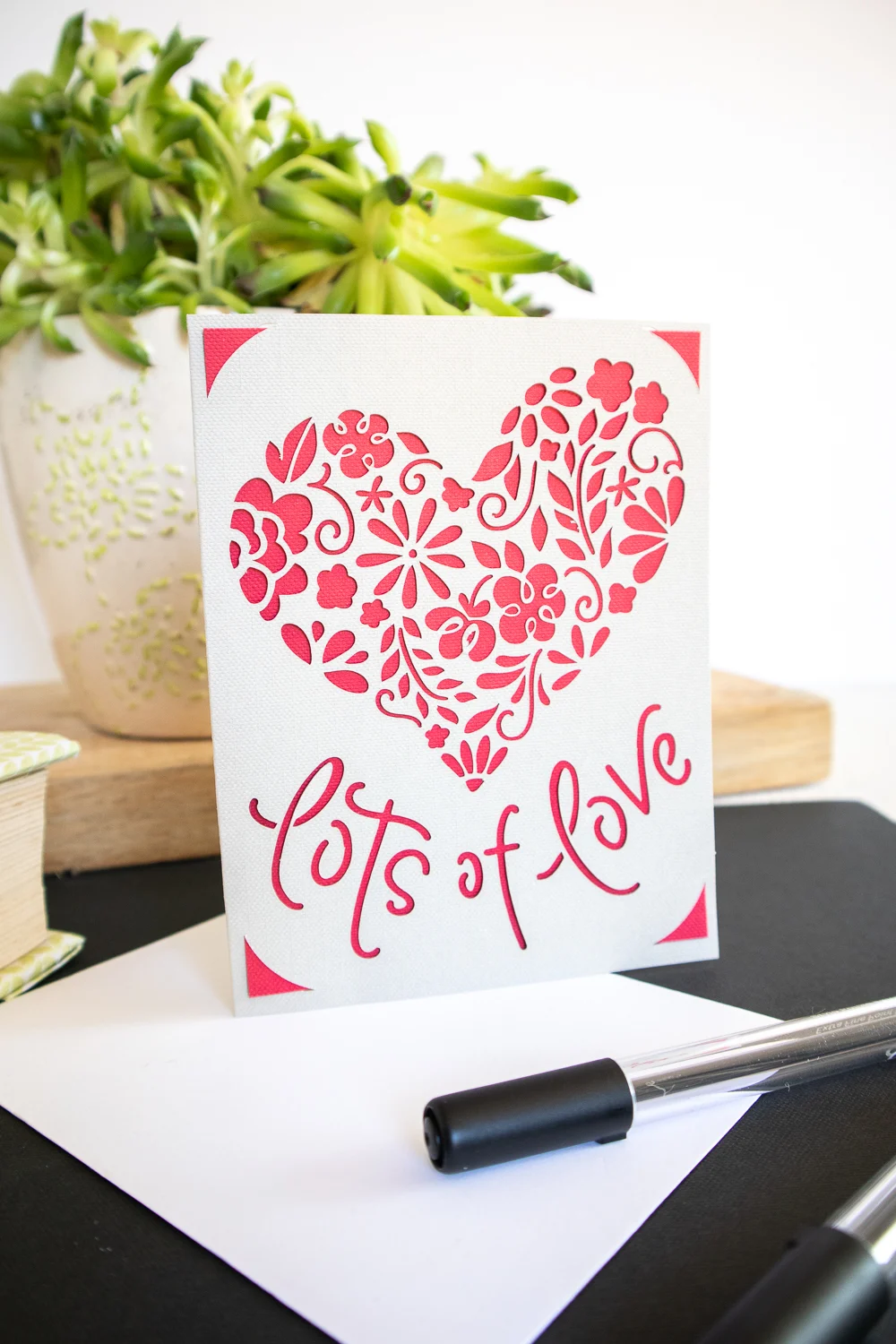 Lots of love detailed heart card on desk with pen.