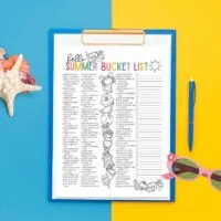 free printable summer bucket list on yellow and blue background with a clipboard, sunglasses and shells.